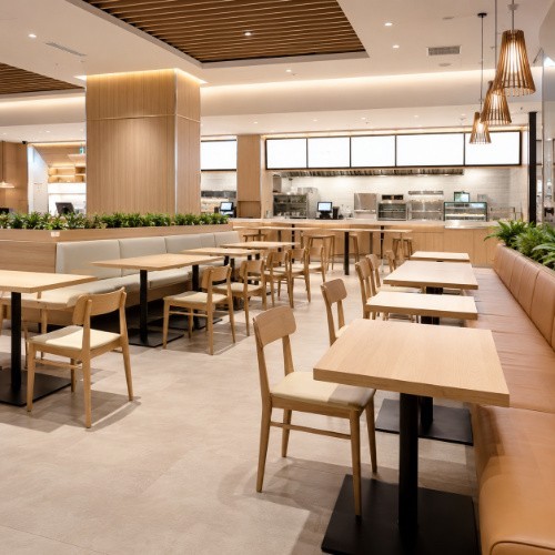 Wooden QSR and food-court tables, chairs and bench seating in a modern layout